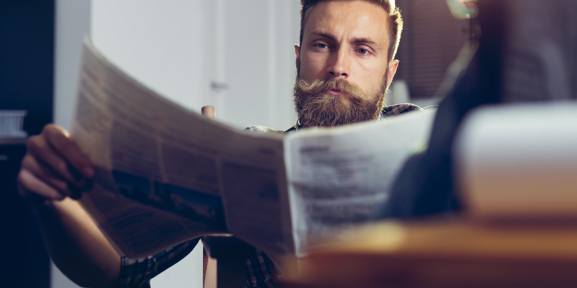 Mann informiert sich über Neuigkeiten in einer Zeitung | © iStock-858508360