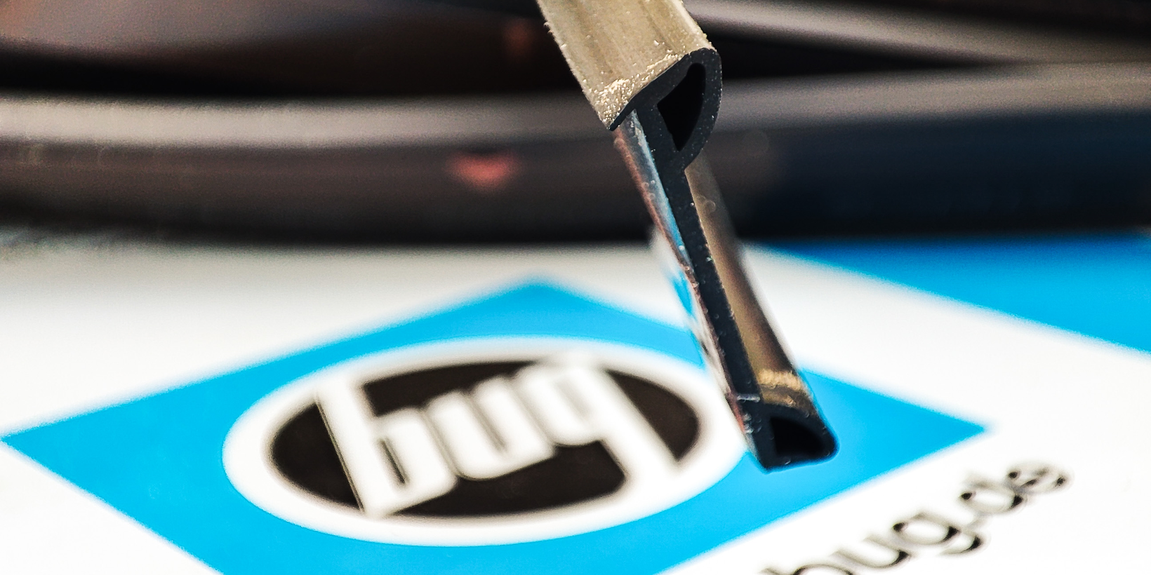 Anschraubdichtung AD 500 mit Stülpnase und zwei Kammern im Vordergrund des BUG Logos