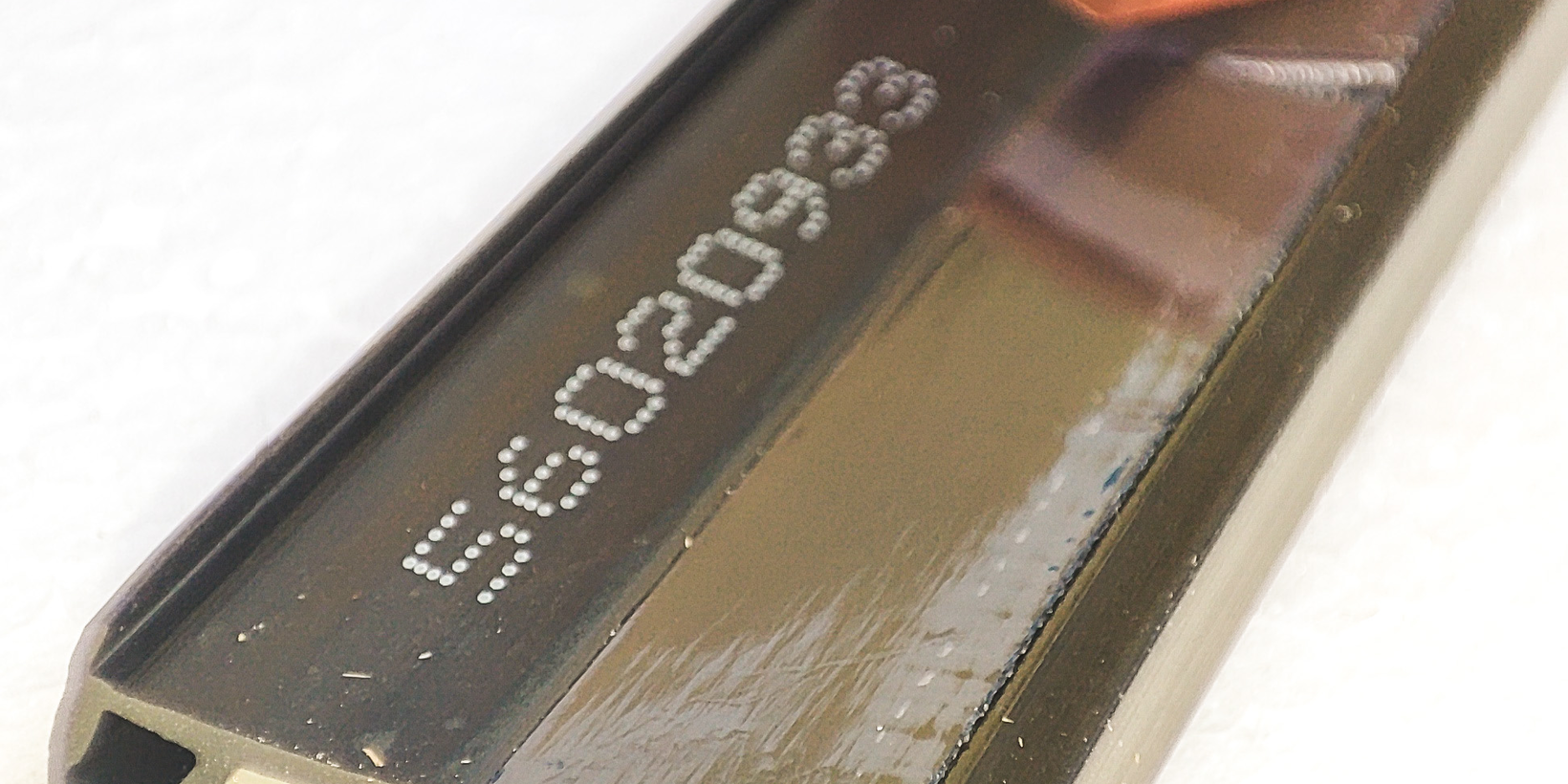 Rückseite der schwarzen Anschraubdichtung AD 500 mit Klebestreifen und abgelöster Klebefolie