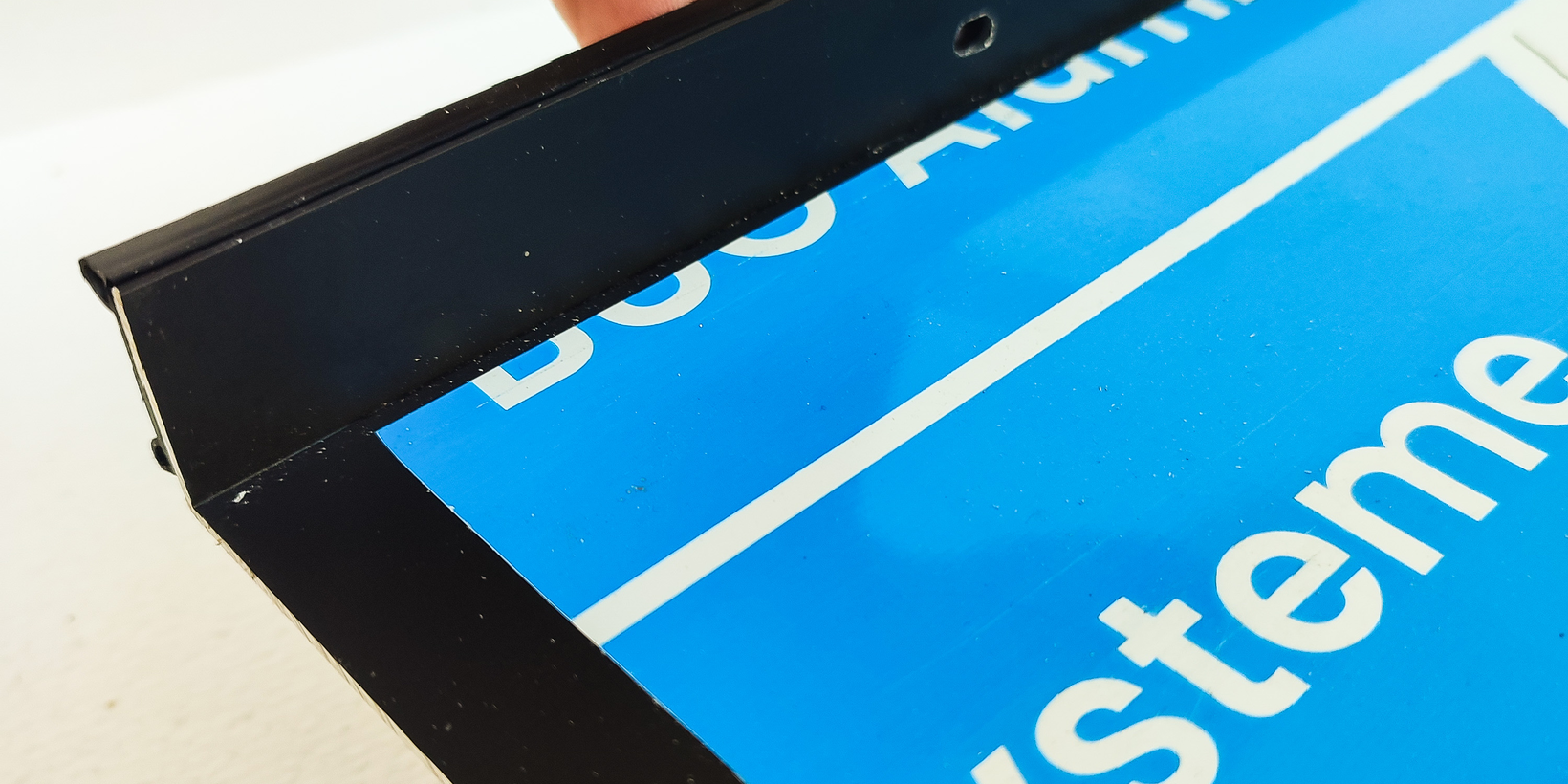 Lösen der Folie bei der positionierten Anschraubdichtung AD 500 am Anschraubsteg einer schwarzen Fensterbank