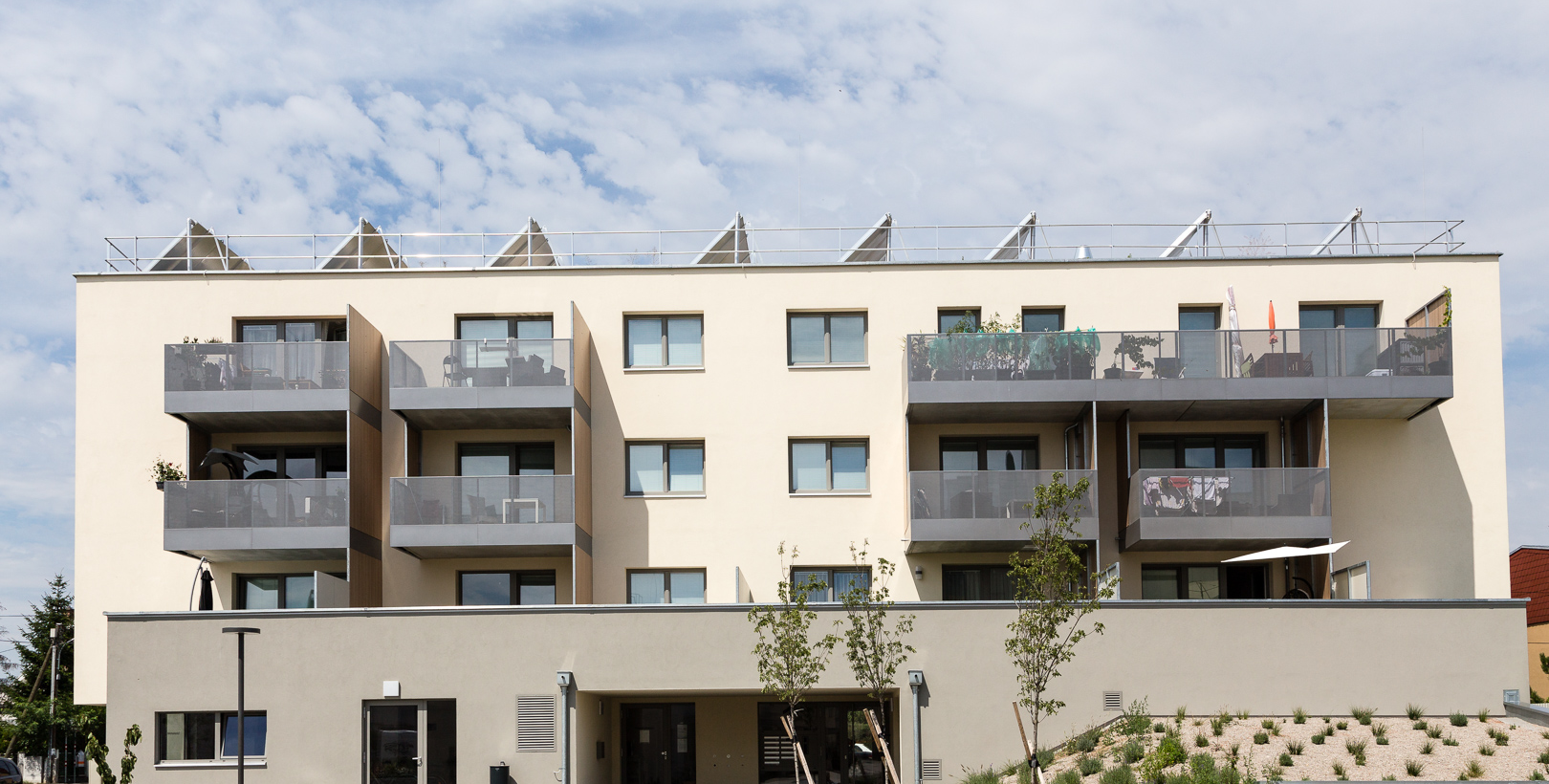 Frontansicht des hellen Flachdachgebäudes mit Balkon in der Portheimgasse in Wien Donaustadt