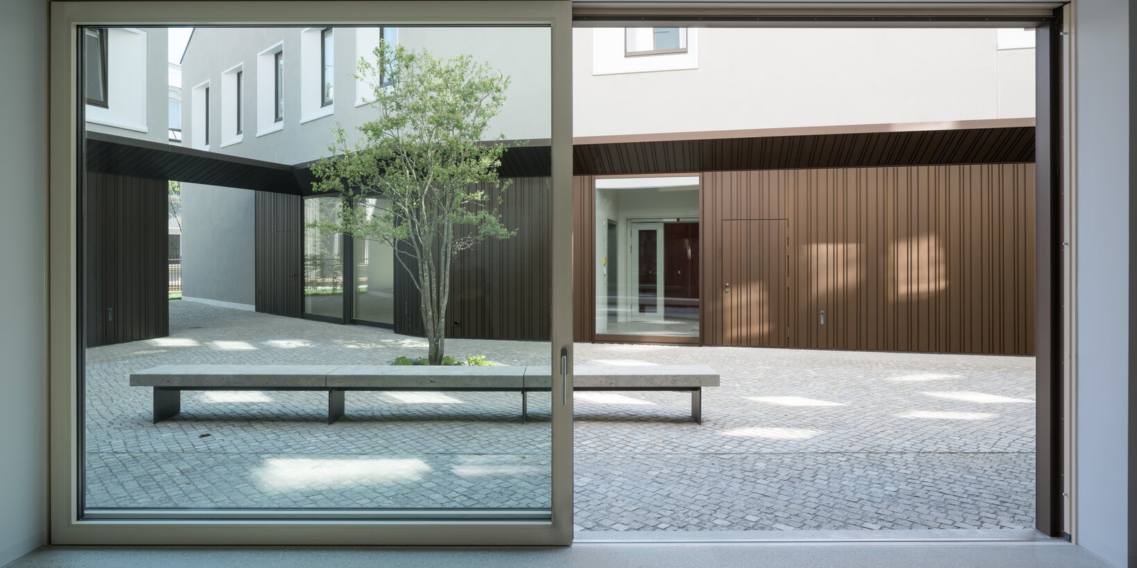 Innensicht der Hebeschiebetüre von BUG nach außen in den Innenhof des evangelischen Zentrums in Augsburg