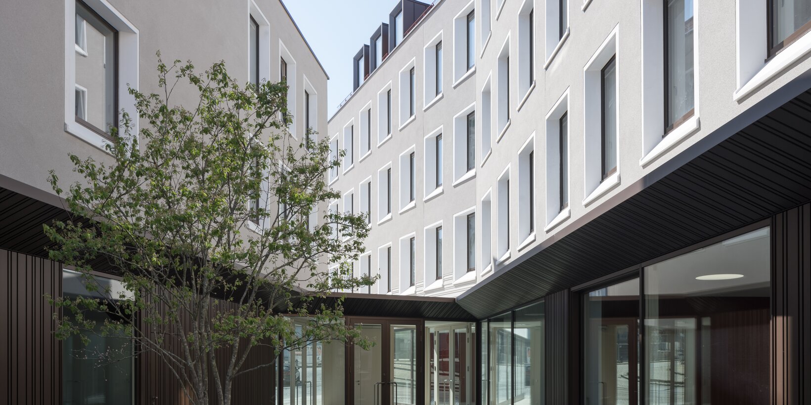 Innenhofansicht des evangelischen Gemeindezentrums in Augsburg mit Holz-Aluminium-Fenster von BUG