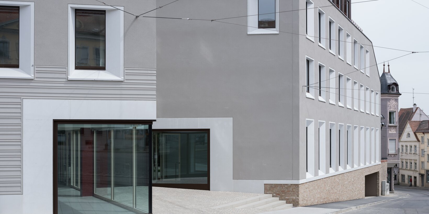 Fassadenansicht des evangelischen Zentrums in Augsburg mit eingebauten Holz-Aluminium-Fenstern von BUG