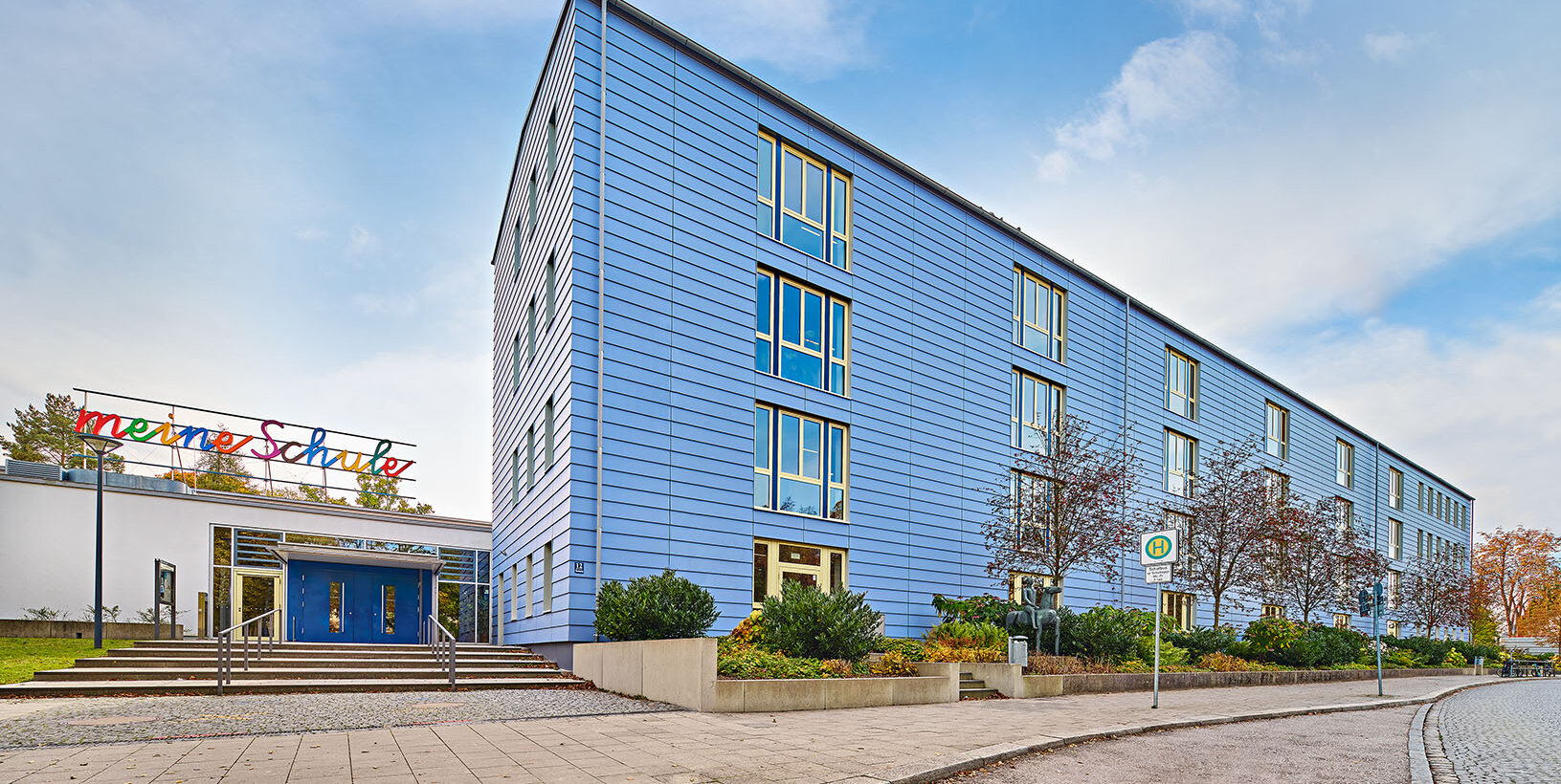 Gebäudeansicht der Grundschule Amphionpark in München mit Holz-Aluminium-Fenster von BUG