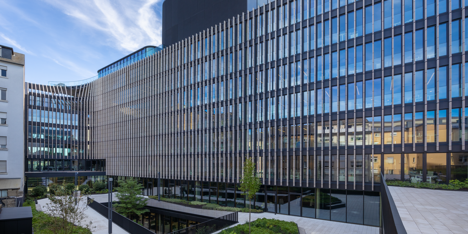 Moderne Fassade des Gebäudes der Post Luxembourg mit grünem Vorplatz