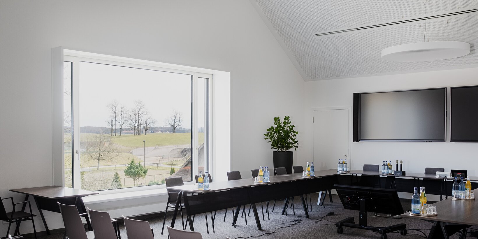 Gemeindesaal des Rathaus Wolfegg mit großen flächenversetztem Holz-Aluminium-Fenster von BUG