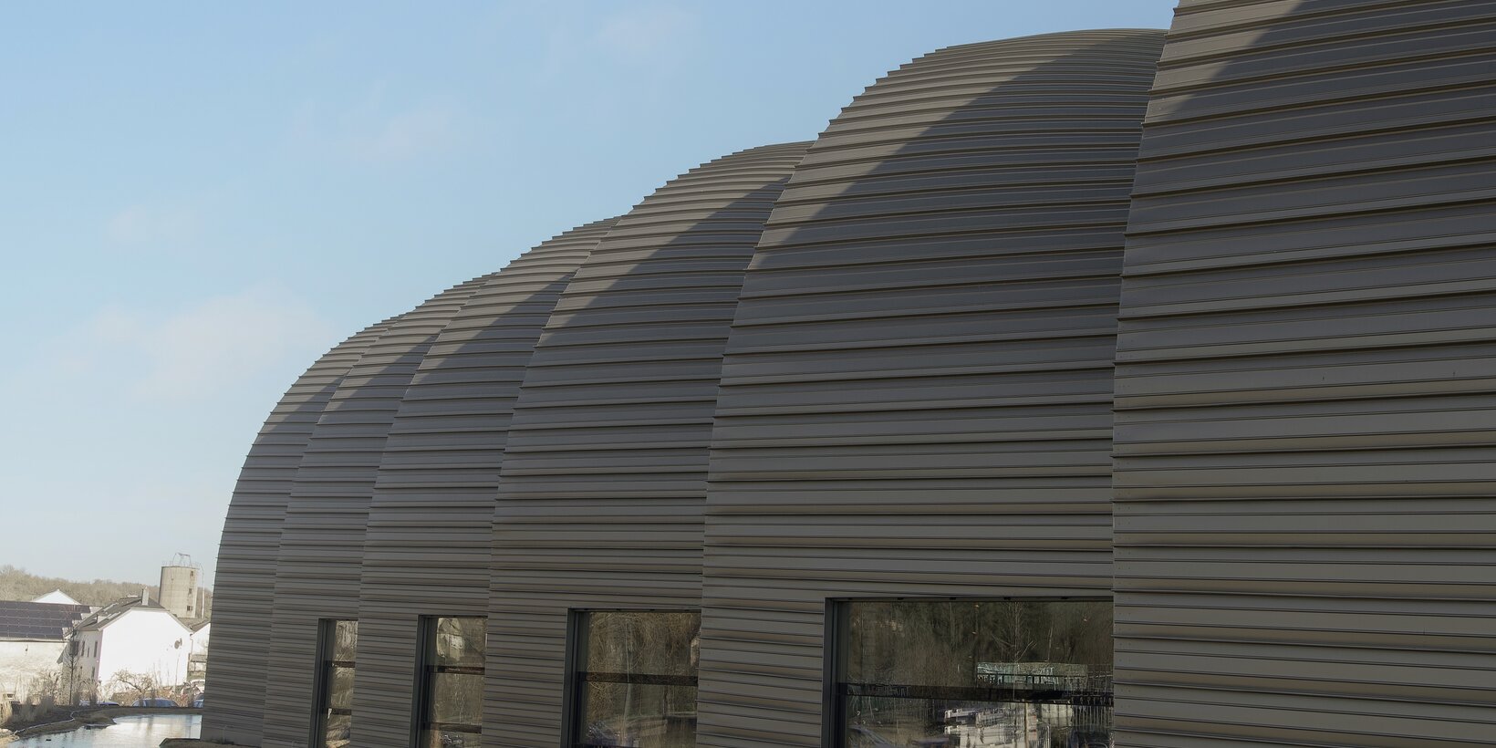 Fassadenansicht der Bögen und BUG Holz-Aluminium-Fenster von der Werkhalle und Bürogebäude von Annen plus