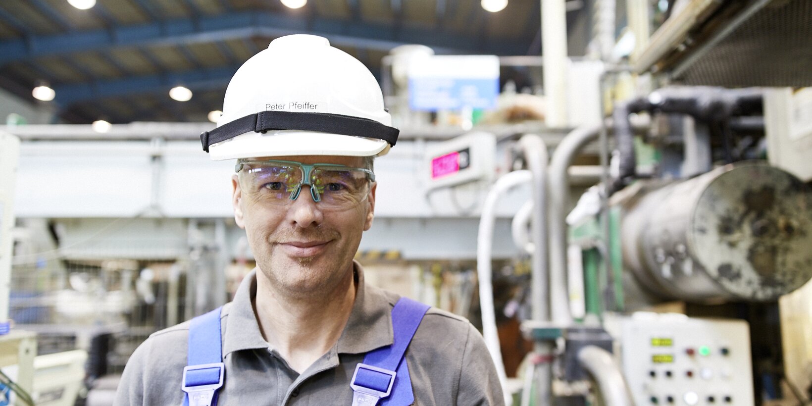 Mitarbeiter vor einer Maschine am Standort in Bitterfeld